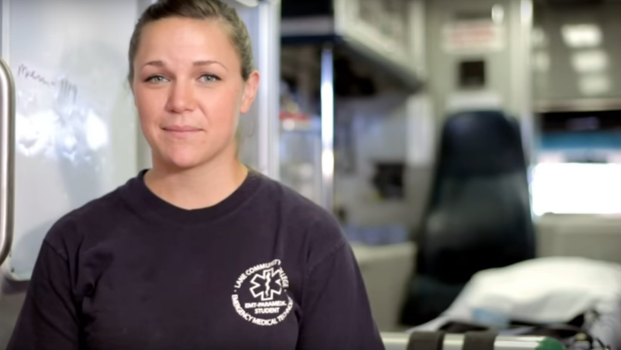 an EMT student in front of an open ambulance