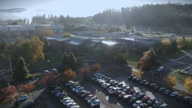 a drone shot of LCC campus showing morning clouds rolling through the trees
