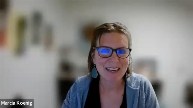 Marcia Koenig, a friendly woman with long brown hair and glasses, talks to the camera via a Zoom recording